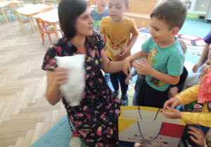 Pani Martyna przekazuje dzieciom niespodziankę od pana Pączka.