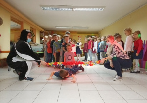 Kolejne dzieci przechodzą pod liną