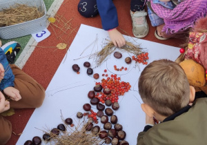 Dzieci układają z materiału przyrodniczego portret Pani Jesieni