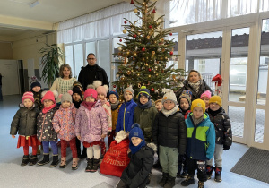 Grupowe zdjęcie na tle choinki.