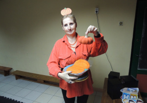 Ciocia Gosia pokazuje nam piękną dynię - wygląda jak prawdziwa.